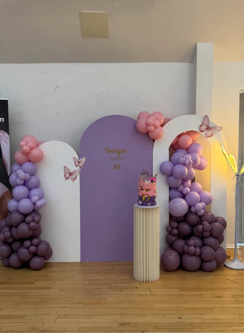 Lilac and pink balloon arches with butterflies and a cake plinth for a 10th birthday