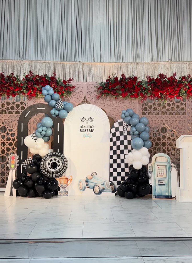 Race car themed party set with checkered flags, road arch and blue balloon garlands